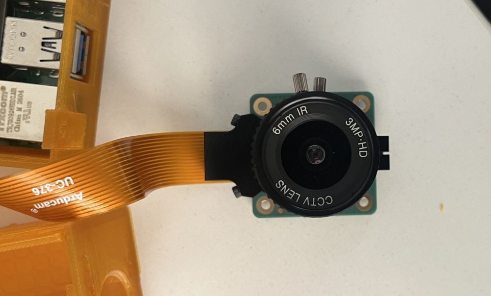 Inside the camera: compute board, ribbon cable and a CCTV-grade lens module